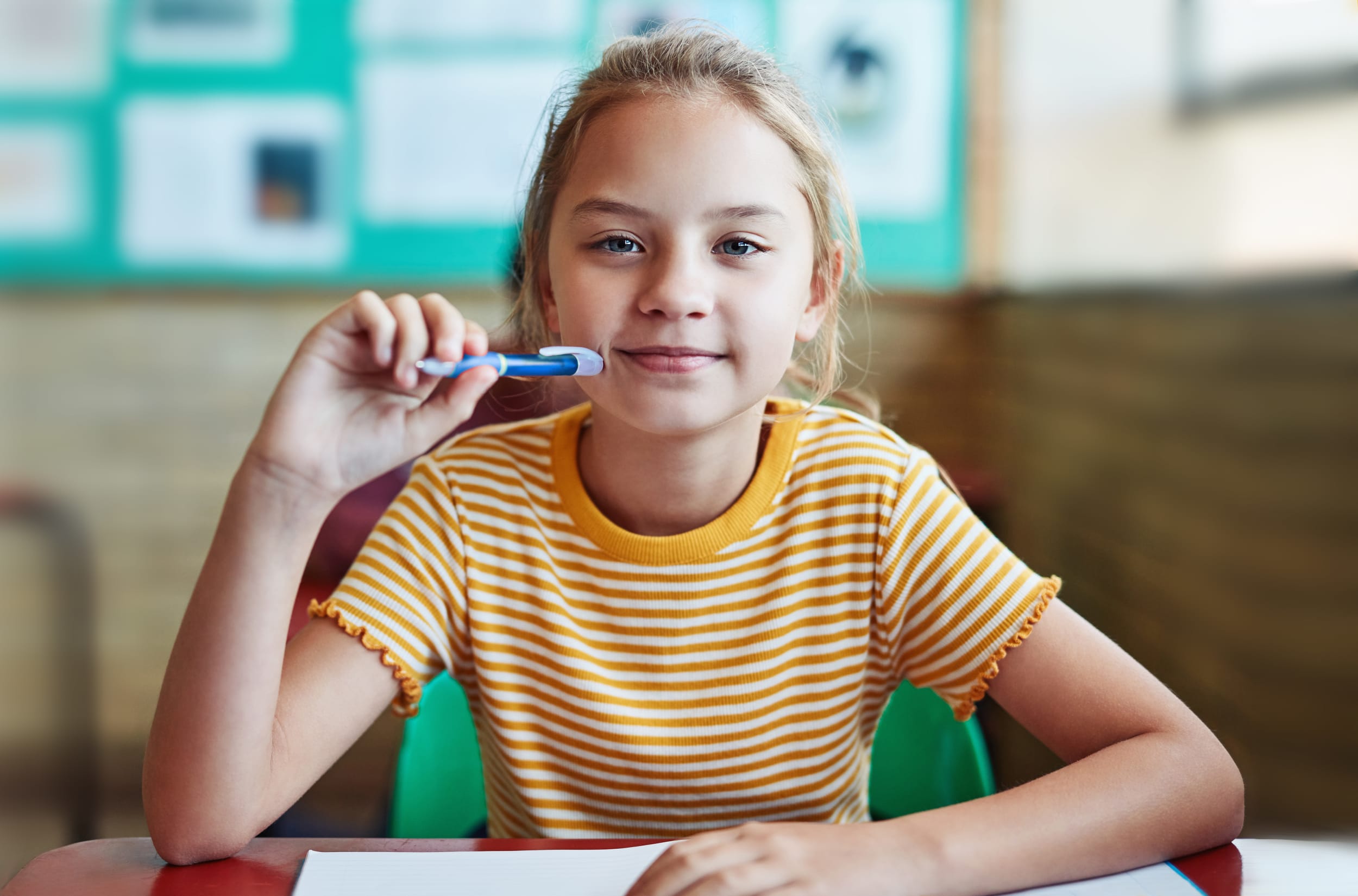Ung elev som sitter på skolepulten sin